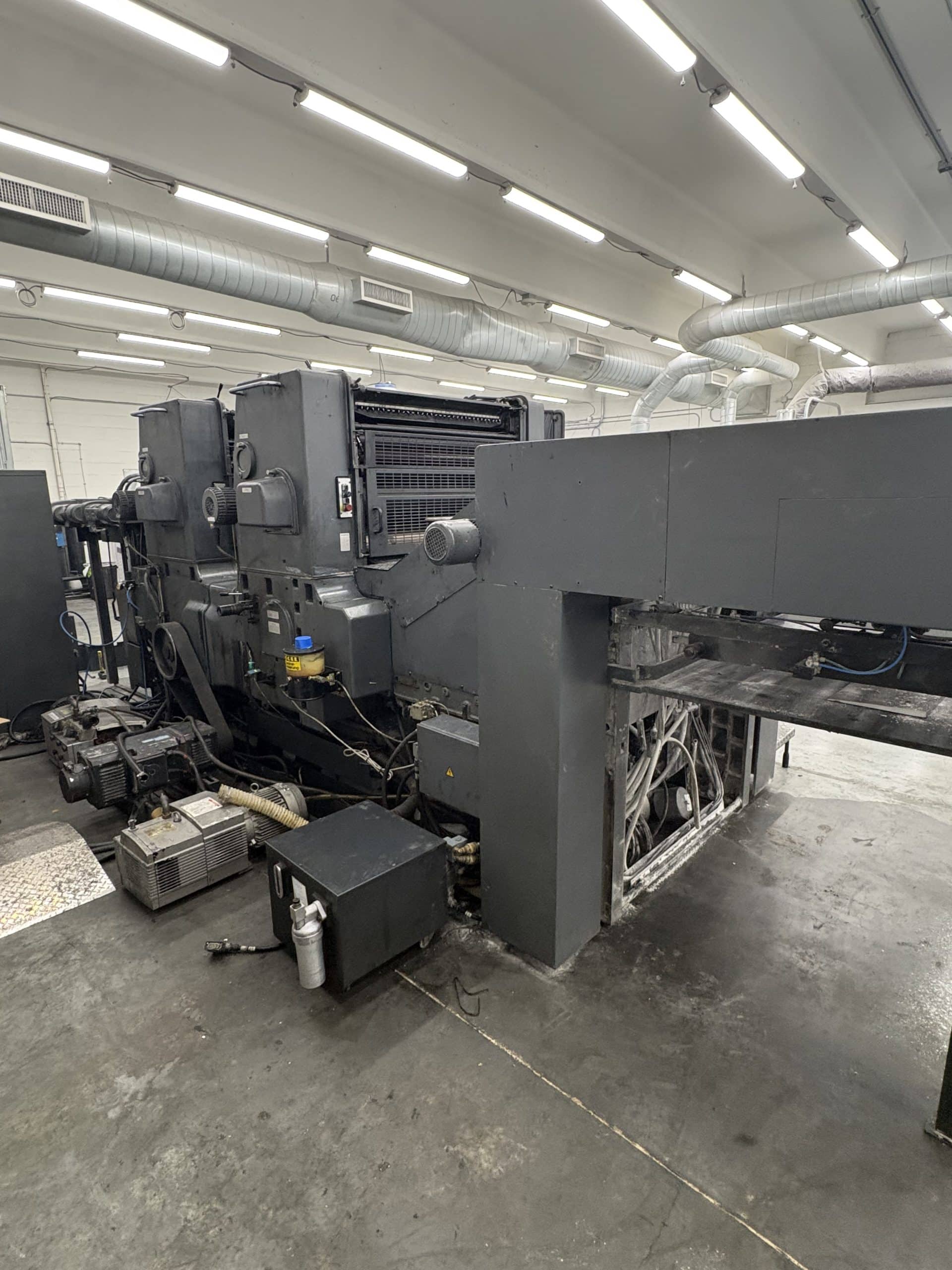 Rigging crew moving heavy industrial machinery inside a working facility